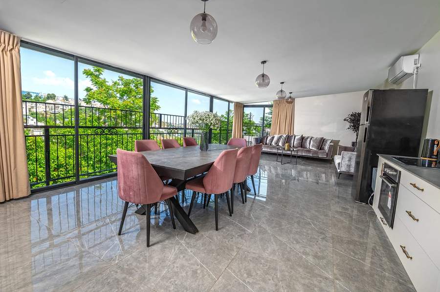 Grand dining table and living room with hillside view