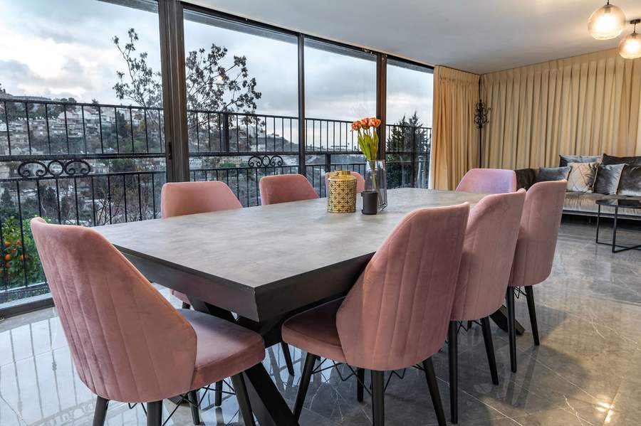 Dining table with fresh flowers and hillside view