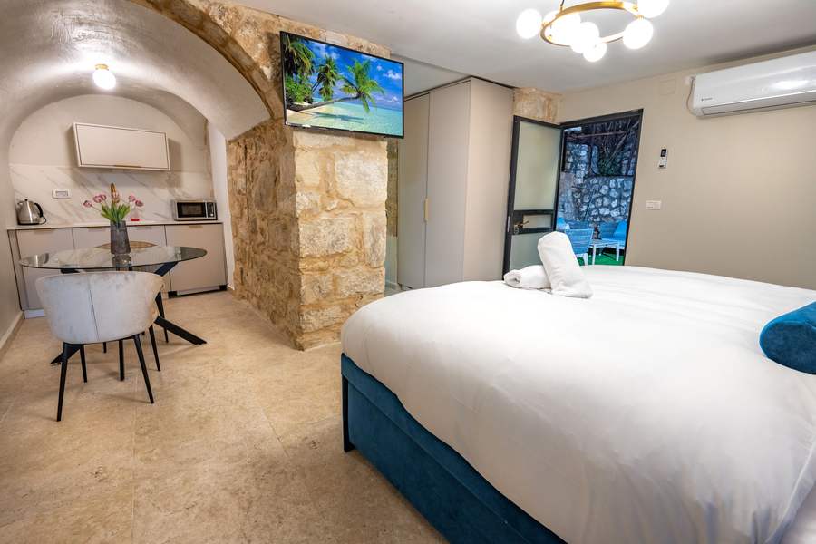 Suite bedroom with kitchenette and stone archway