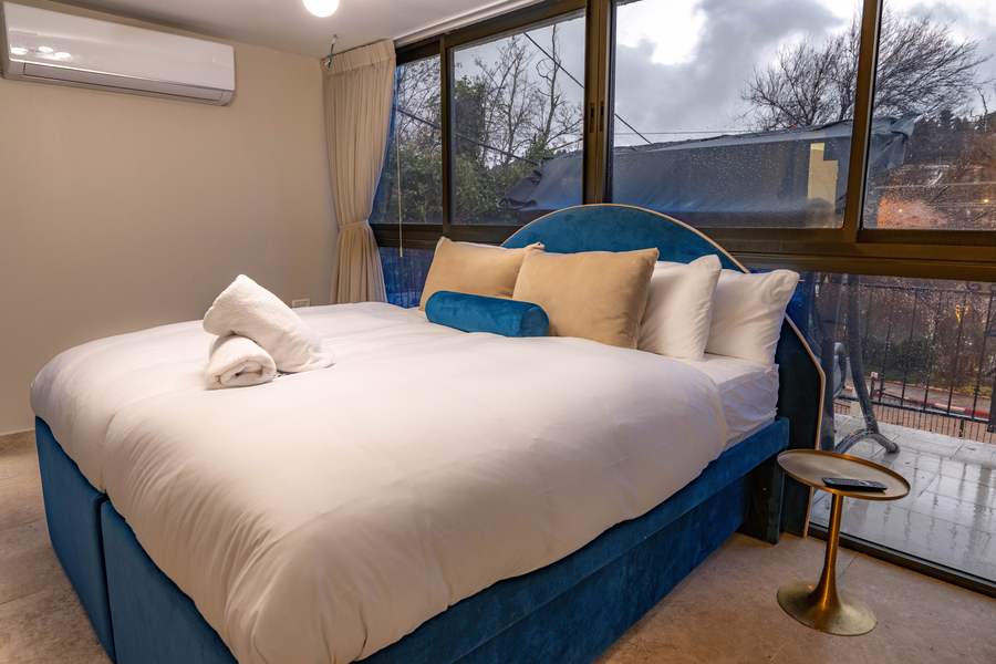 Suite bedroom with large windows and hillside view