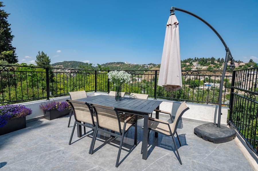 Rooftop terrace dining table with hillside view